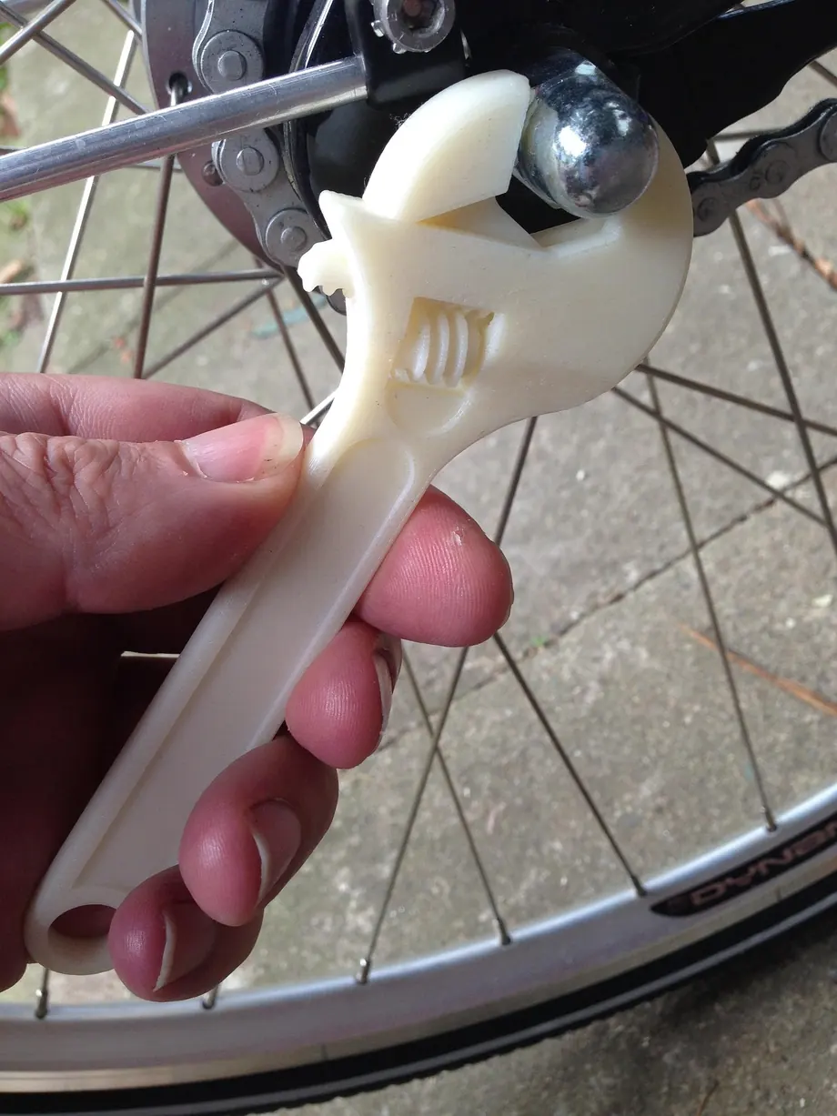 A 3D printed spanner in use on a bicycle